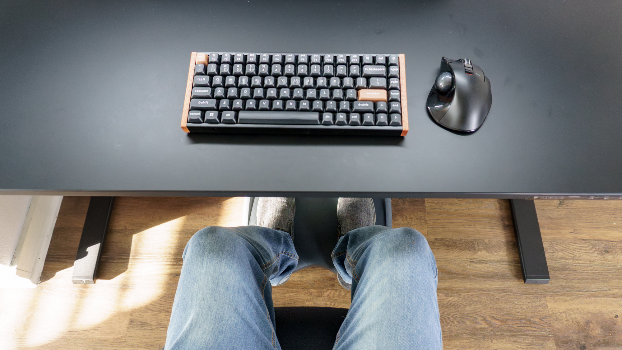 An overhead view of a person resting their feet on the LiberNovo StepSync footrest