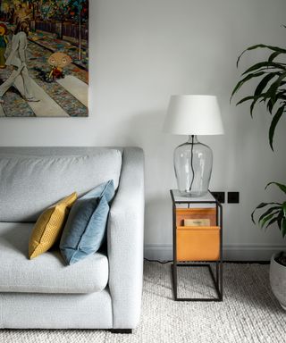 A minimalist living room with a gray color scheme and a white lamp