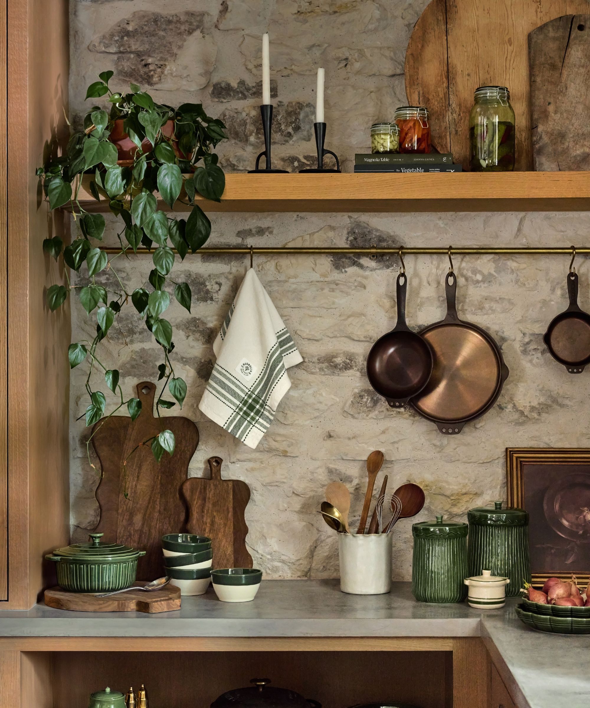 Kitchen with countertops with chopping boards, ceramic jars, utensils, copper pans and pot rail