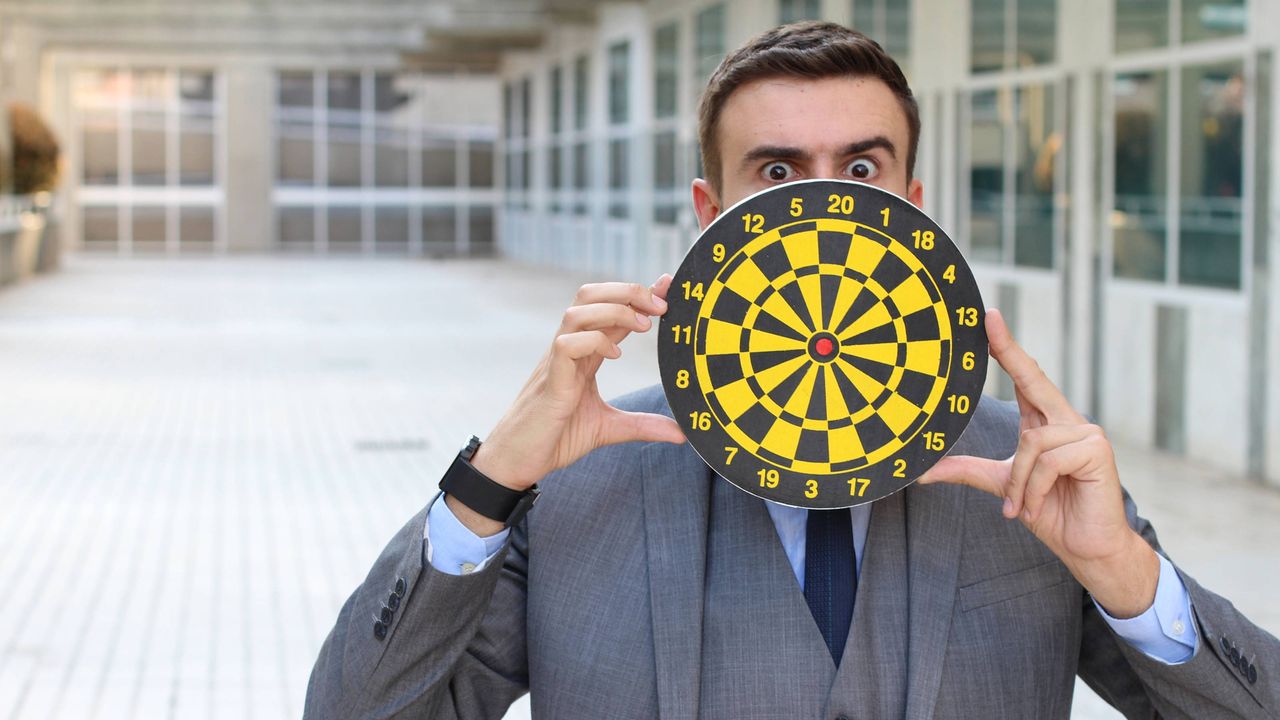 A man peeks out from behind a target.