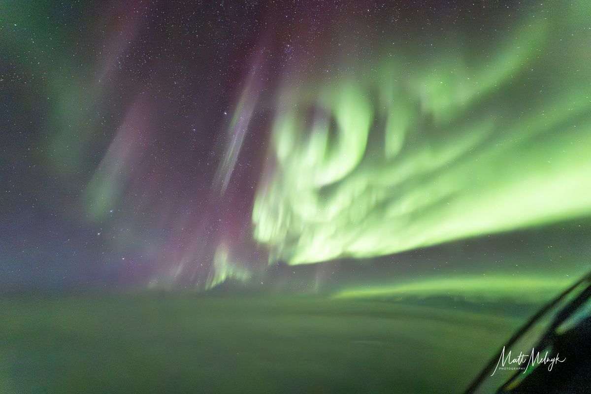 ribbons of green and purple light fill the sky in photos captured above the clouds from a dreamliner airplane.