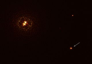 This image, captured by the SPHERE instrument on the European Southern Observatory's Very Large Telescope in Chile, shows the most massive known planet-hosting star pair, b Centauri (at left), and its giant planet b Centauri b (arrow). The bright dot in the upper right is a background star.