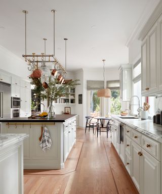 kitchen with white cabinets and island with walnut countertop marble backspash and wooden floor