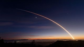 the bright streak of a rocket's thrust across the night sky above southern California in a time lapse exposure