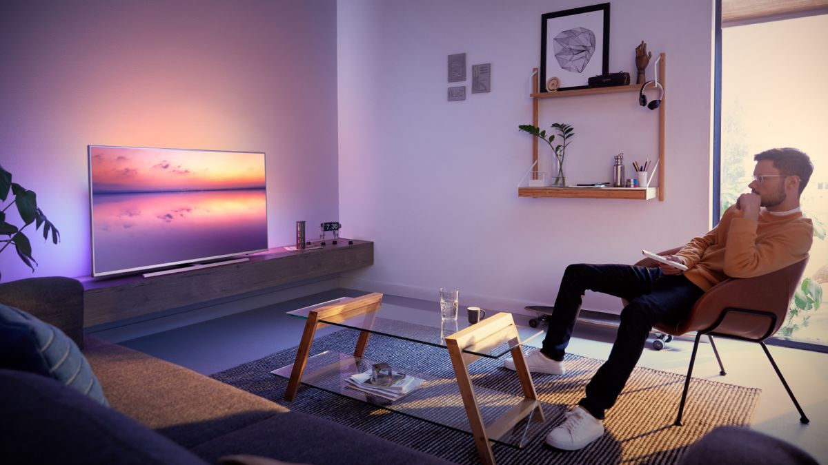 Philips TVs Ambilight gløder rundt en TV i et oppholdsrom.