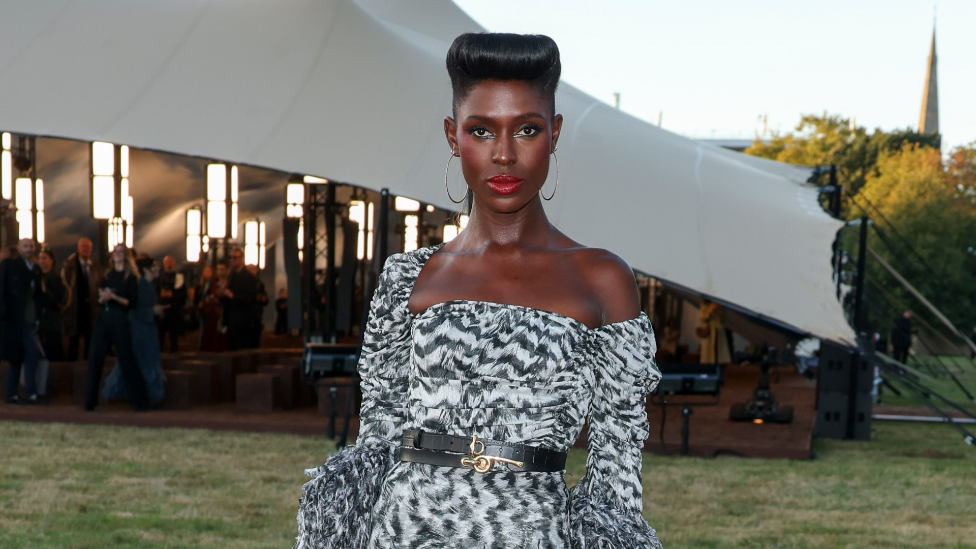 Jodie Turner Smith wearing an off-the-shoulder dress, red lipstick, and an updo