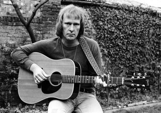 Dennis Waterman with an acoustic guitar in 1975