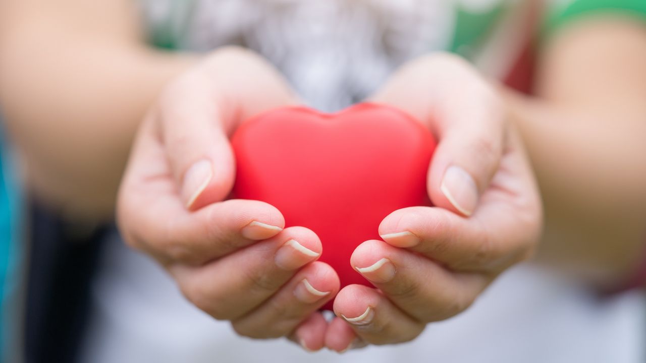 A woman&#039;s hands cradle a heart knickknack.