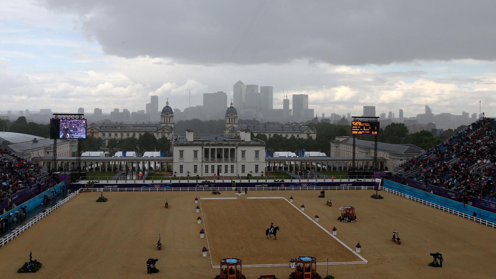 Tina Cook performs her dressage test at the London 2012 Olympics in the rain with dark clouds overhead