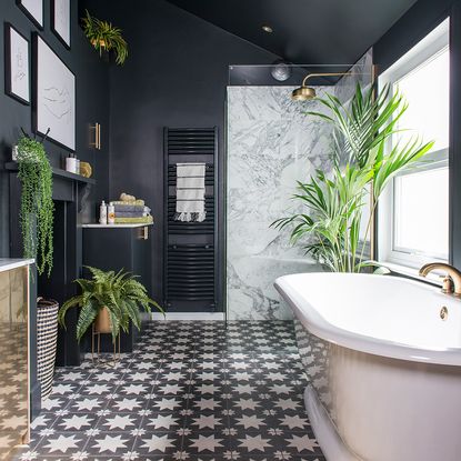 Black bathroom makeover with patterned floor tiles, plants and roll top ...