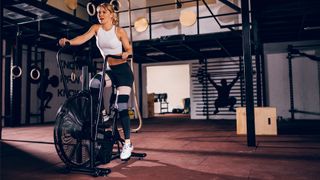 What are the different types of exercise bike: Woman riding an exercise bike in a gym