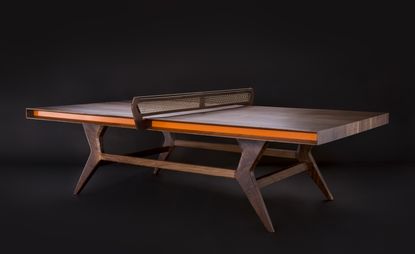 Table-tennis table made from dark wood and with an orange stripe along the side