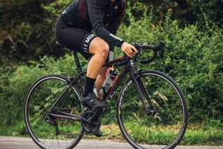 Female cyclist grabbing a bottle while riding