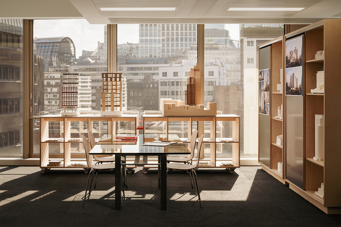 PLP Architecture&#039;s circular office design in neutral colours and soft light, showing empty workspace and timber seating and desks