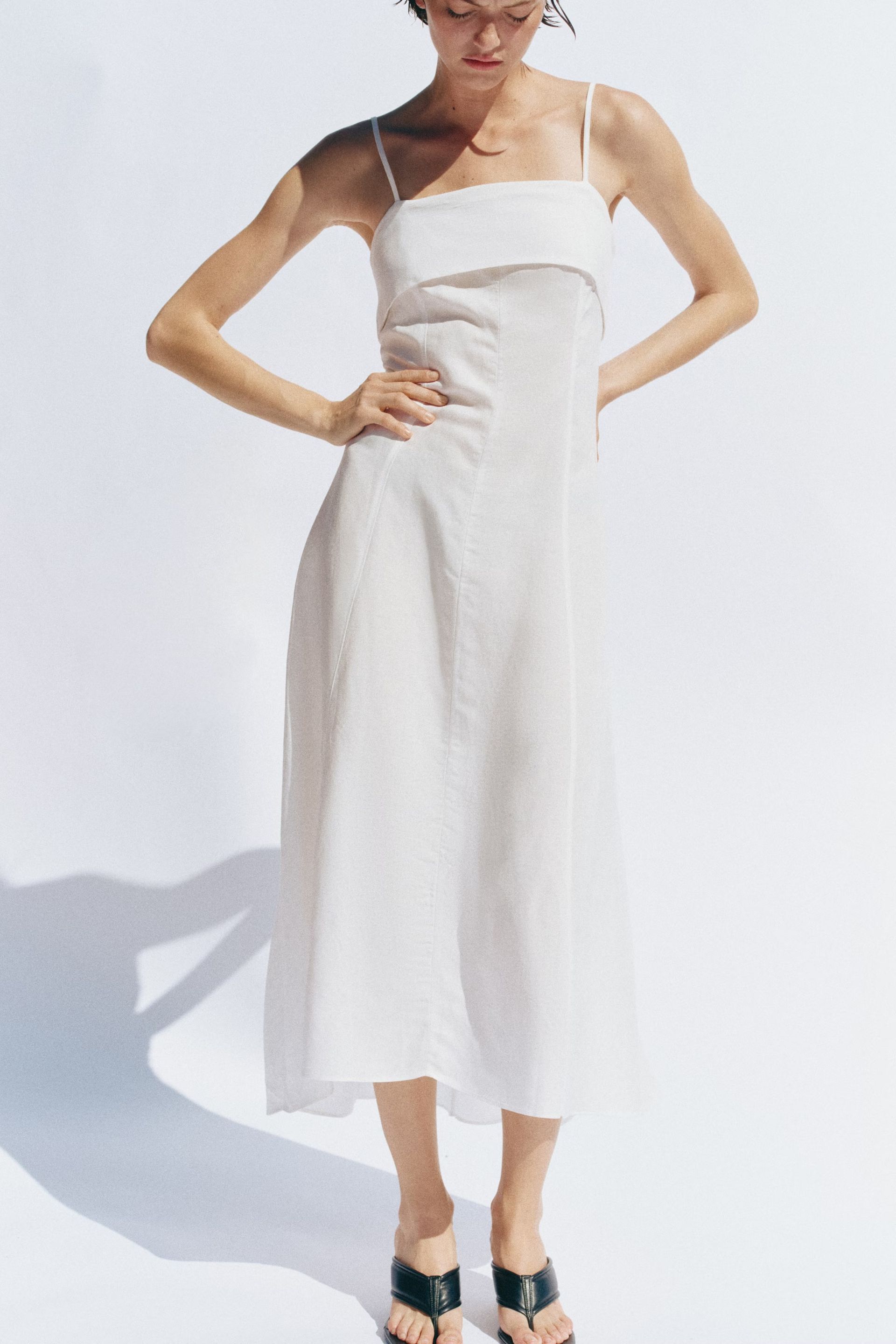 Woman wears white dress and black sandals