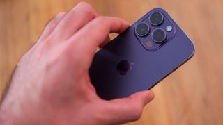 iPhone 14 Pro in purple held in a hand