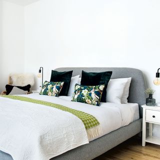 guest bedroom with white wall and bed with pillows