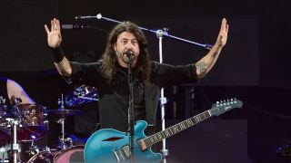 Dave Grohl puts his hands in the air in concert in Roskilde Denmark with the Foo Fighters.