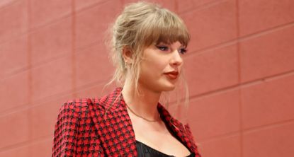 Taylor Swift walks into Arrowhead stadium for the chiefs game wearing a red plaid versace skirt suit