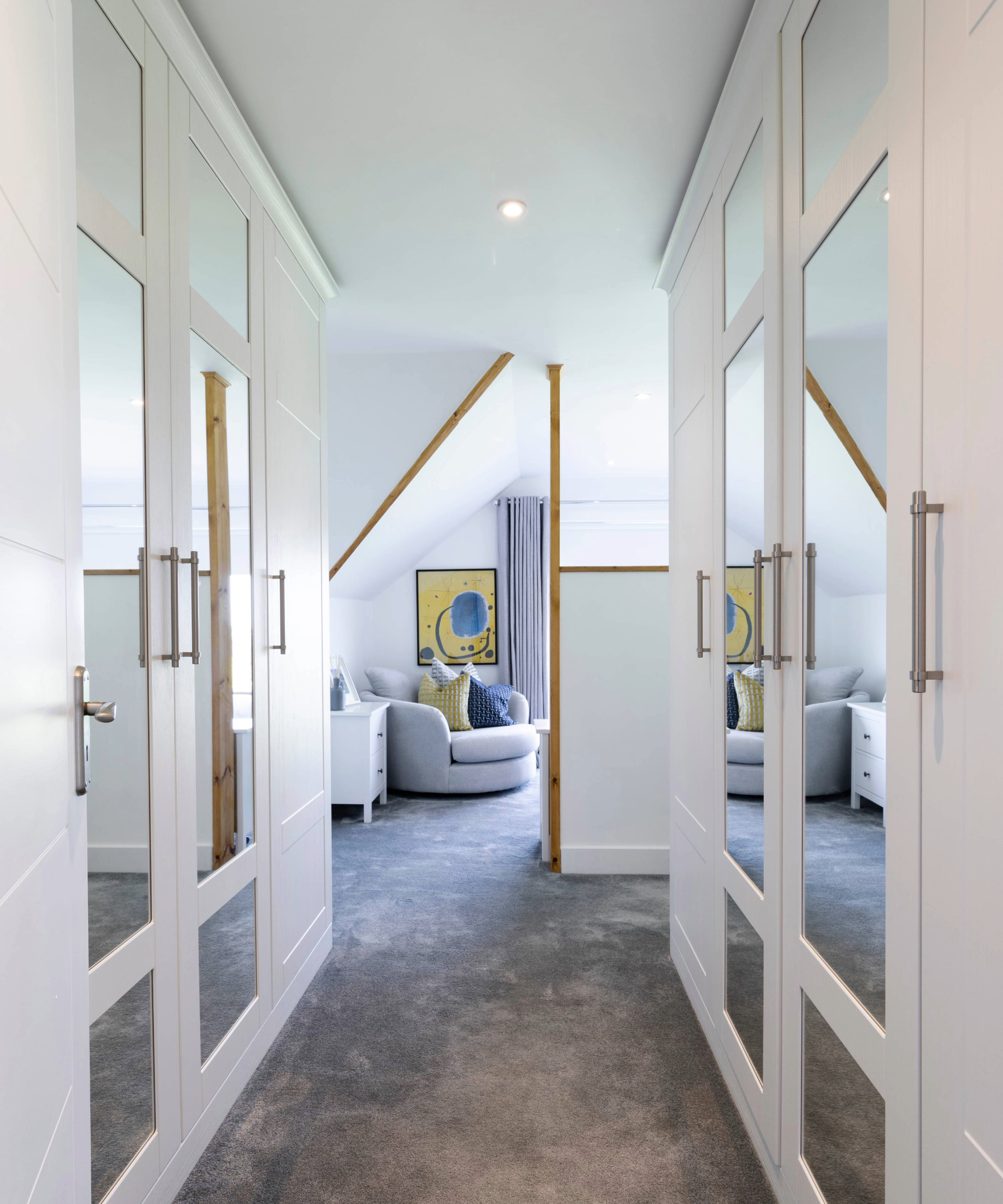 Dressing room with two mirrored wardrobes opposite