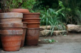 stacks of terracotta pots in a garden