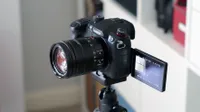 The Panasonic GH5 Mark II vlogging camera mounted on a tripod with its touchscreen pulled out