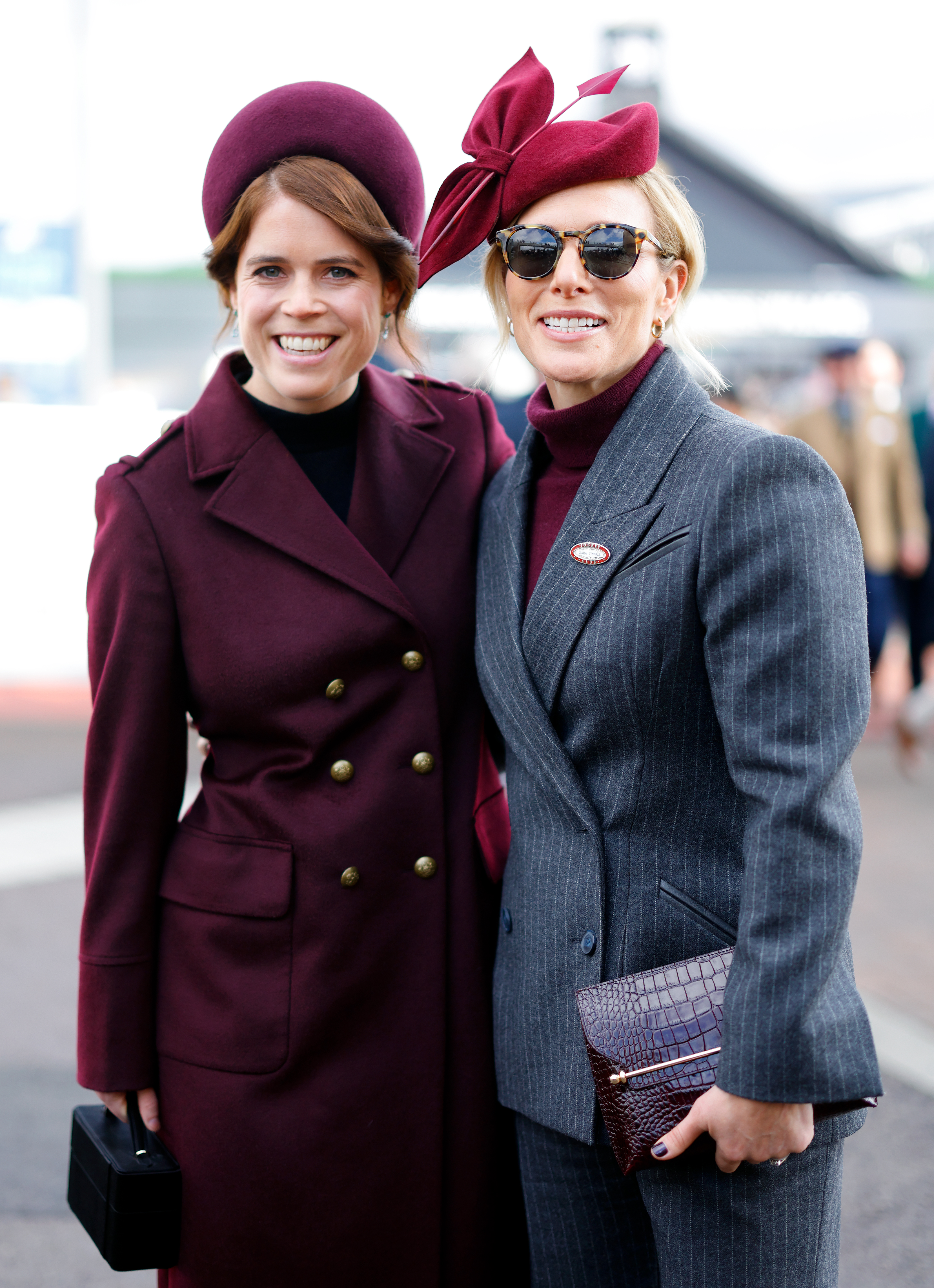Zara Tindall and Princess Eugenie in maroon outfits at Cheltenham Festival