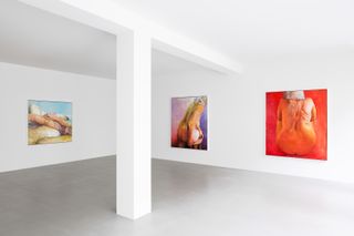 Female nude paintings on white gallery wall