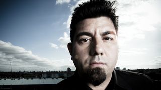 A close-up of Chino Moreno standing on a roof