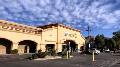 The exterior of a Walmart supercenter under a beautiful sky