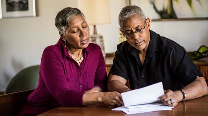 A man and a woman look at financial statements together. 