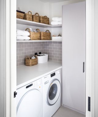 Laundry room storage ideas featuring wall mounted shelving and wicker baskets in an all white scheme.