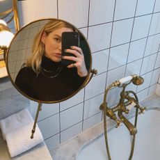 Woman taking a selfie in a makeup mirror