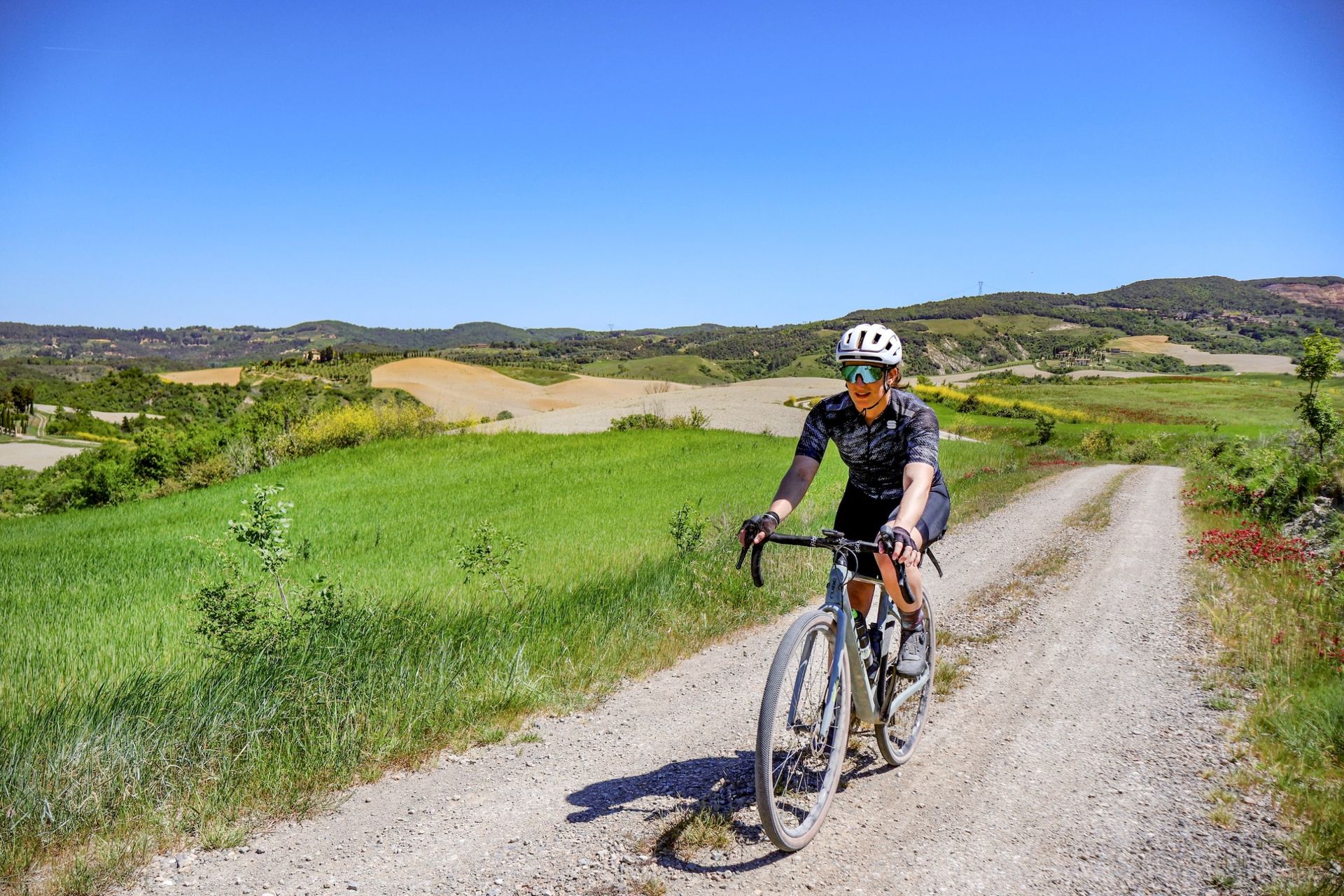 Emma Magnus riding on a white road in Tuscany