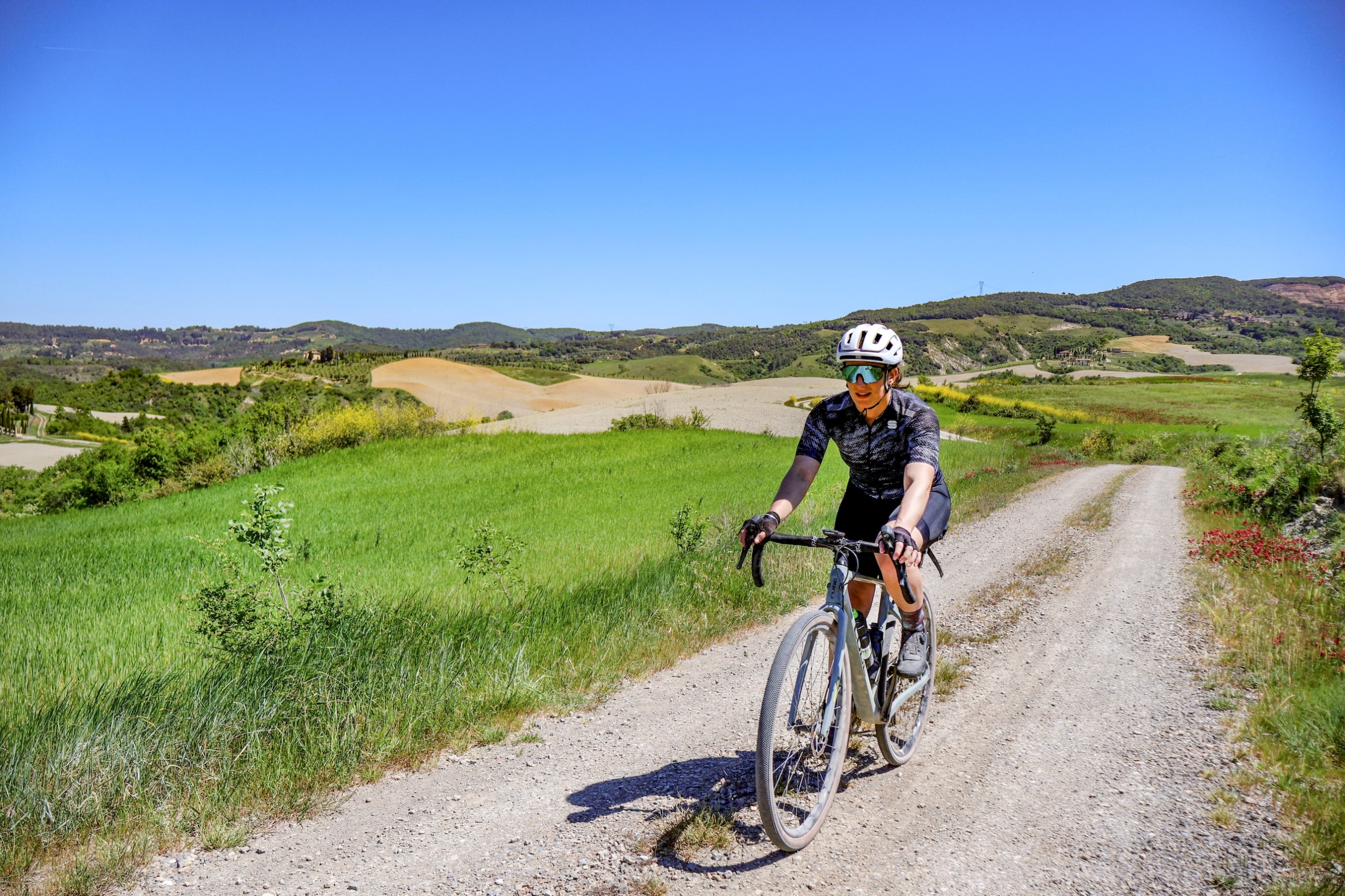 Emma Magnus riding on a white road in Tuscany