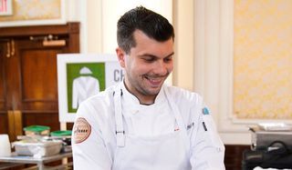 top chef eddie konrad smiling in the kitchen