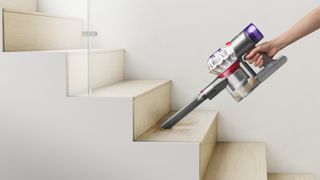 Dyson Car+Boat vacuum cleaner being used on the stairs