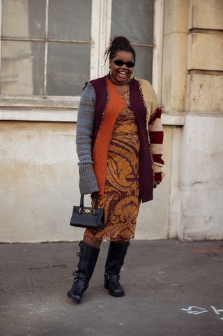 woman wearing sweater dress, cardigan, boots, and handbag