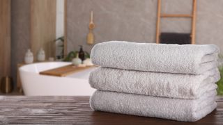 A stack of three white towels in a bathroom