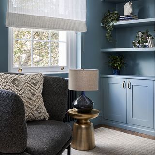 blue living room with blue cabinets shelf and white window