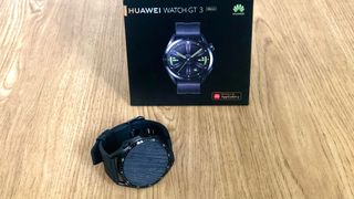 Huawei GT 3 Watch model sat in front of the watch packaging