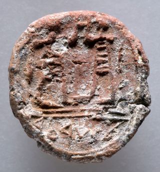 A photo reveals the face of the thin clay seal.
