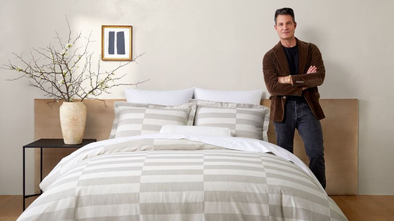 Nate Berkus standing infront of bed with his bedding collection 