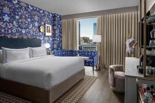 Bright blue patterned wallpaper creates a vibrant atmosphere in a king-sized room at The Dorian hotel in Calgary