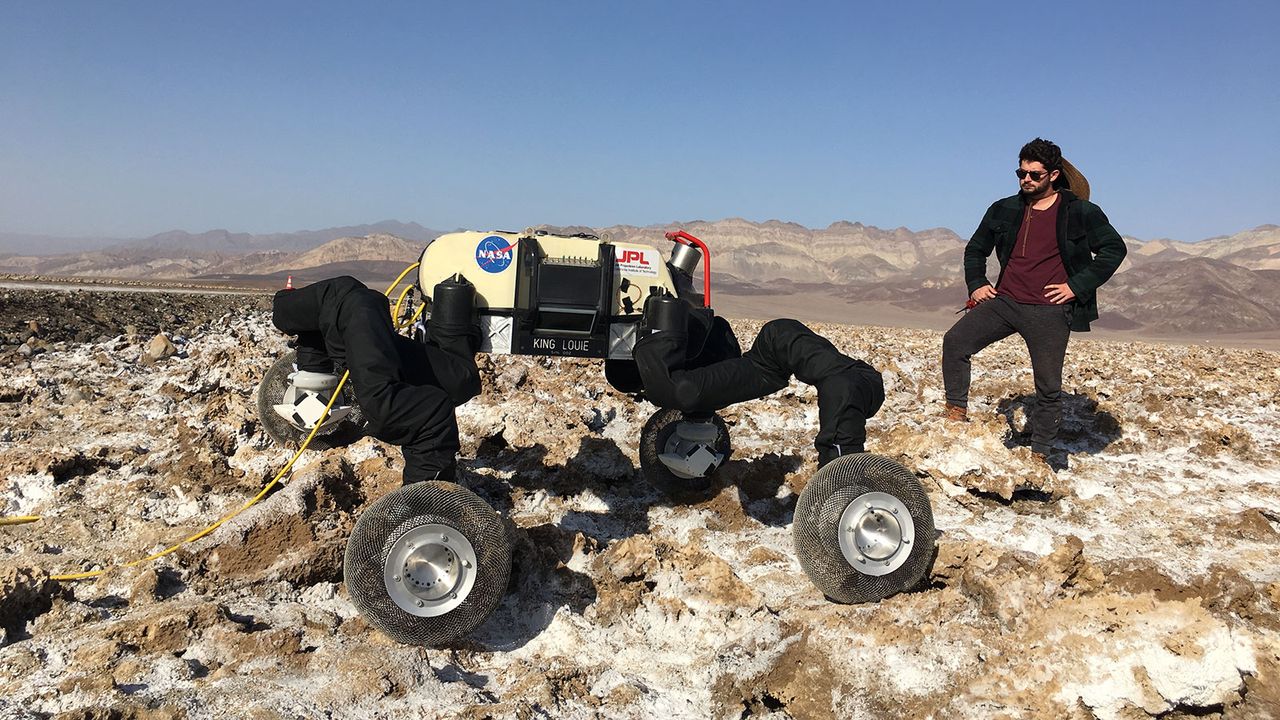 RoboSimian, a robot designed to maneuver on planets like Mars, can walk on four legs, crawl, move like an inchworm and slide on its belly. It stands here in California alongside engineer Brendan Chamberlain-Simon.
