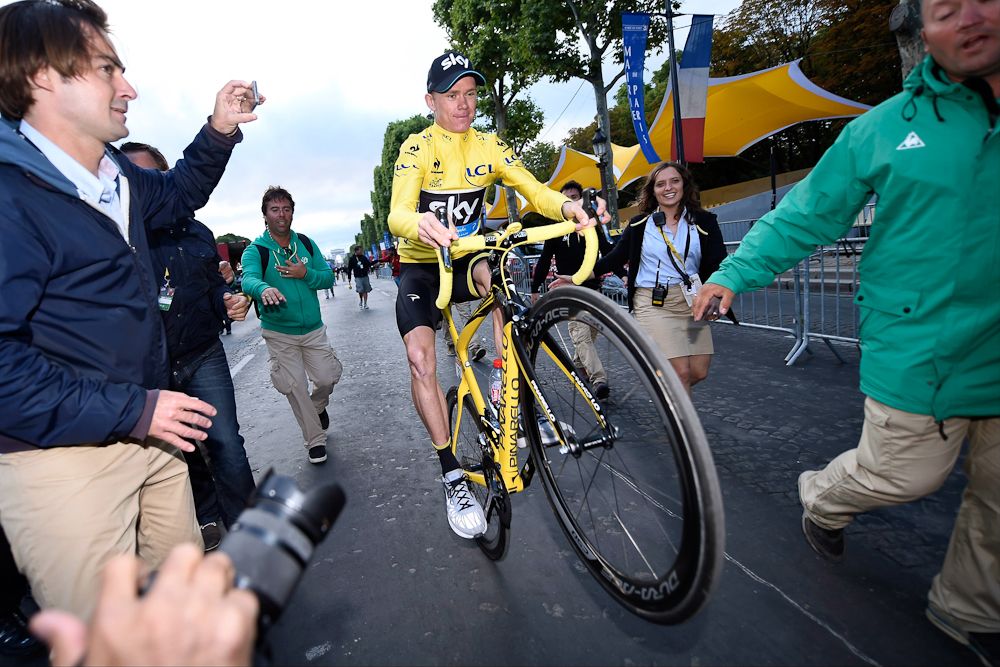 Chris Froome wheelies his way toward the podium following the 2015 Tour de France.