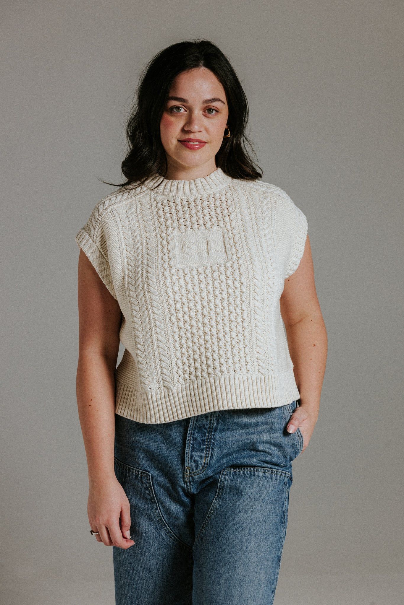A model wears a cream Slow Love knitted tank.
