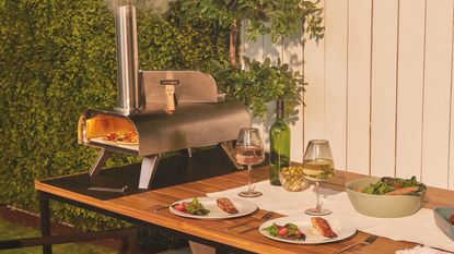 Vonhaus pizza oven in promotional image on table in garden 