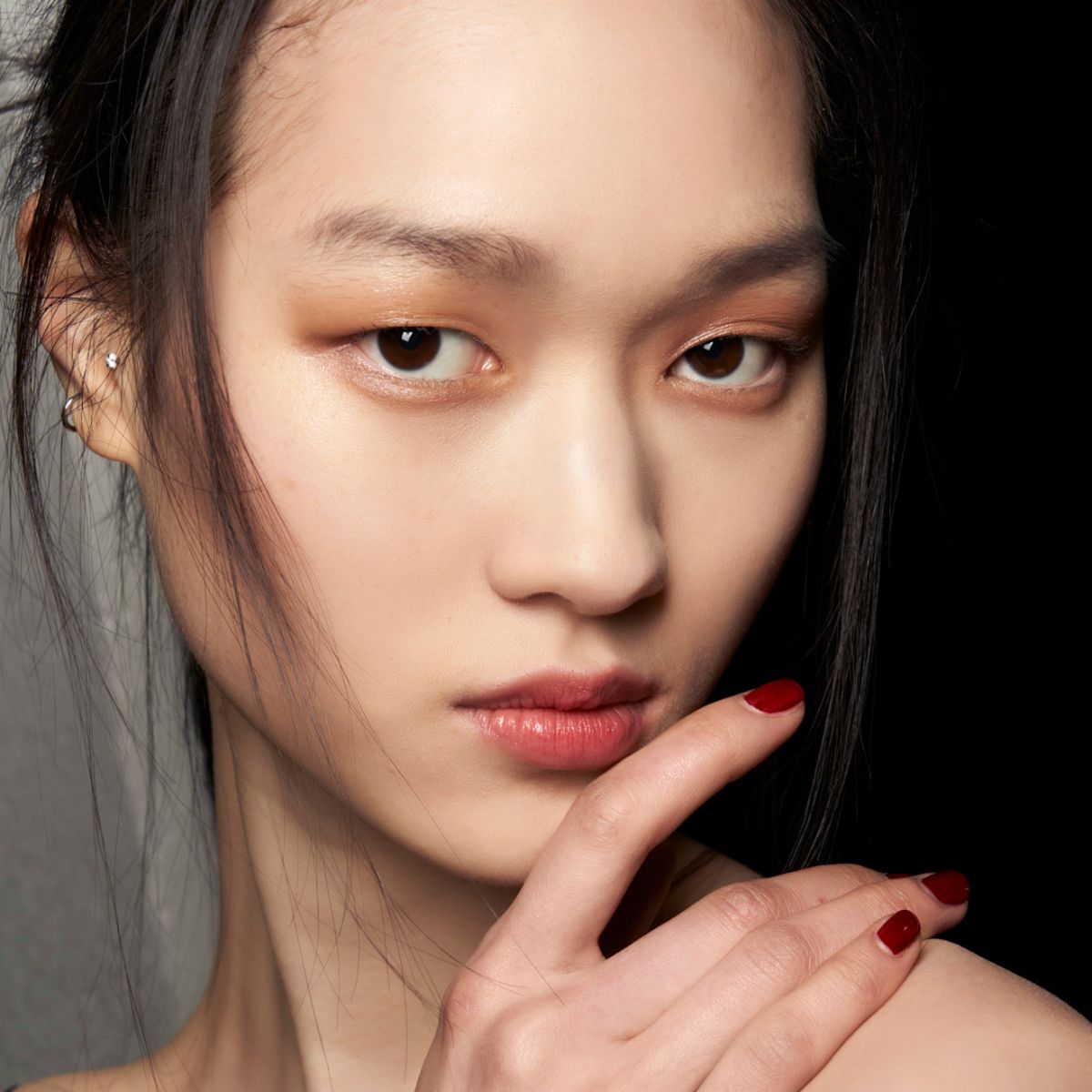 model posing backstage wearing dark red nail polish