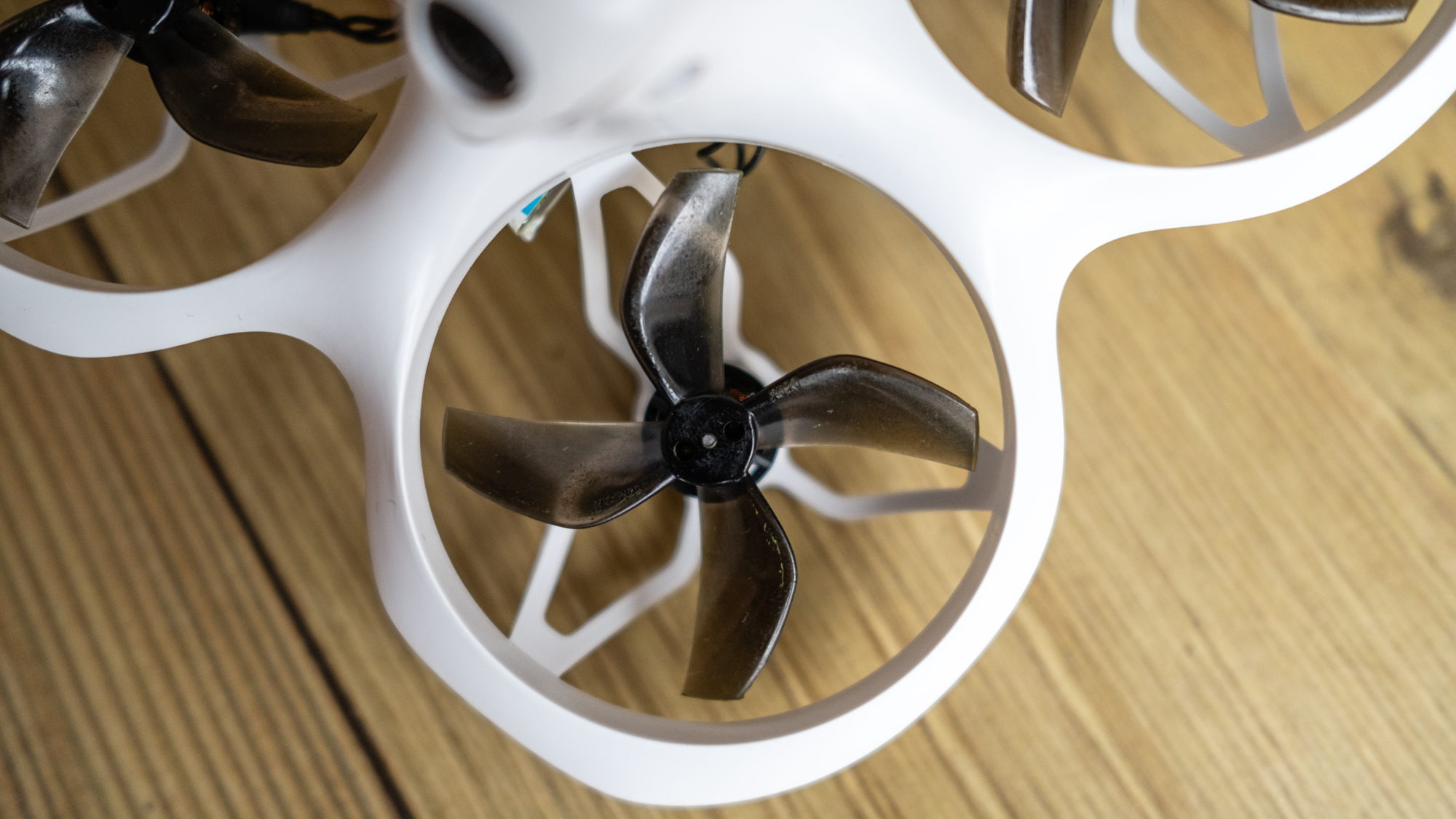 BetaFPX Cetus X drone on wooden table closeup of a single propellor